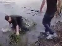 Two drunk guys fighting it out at a lake